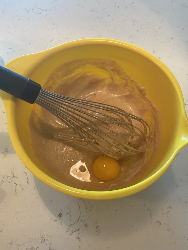 Adding egg to banana bread batter